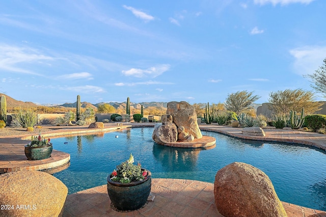 view of pool featuring a patio area and a mountain view