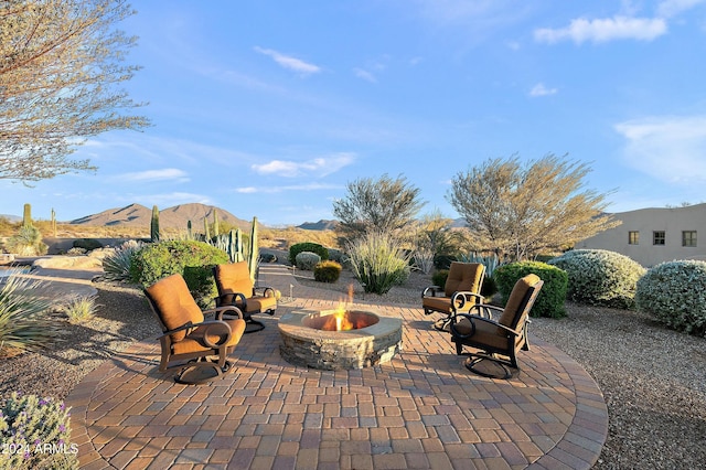 view of patio with a fire pit and a mountain view