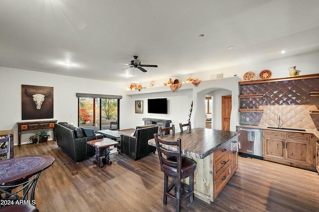 kitchen with dishwasher, a center island, dark hardwood / wood-style floors, and a breakfast bar area