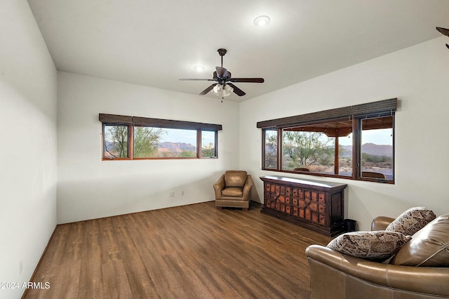 living area with ceiling fan and dark hardwood / wood-style floors