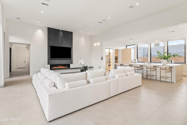 living room featuring a large fireplace and light tile patterned floors