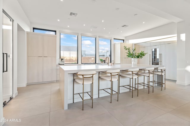 kitchen featuring a spacious island, a breakfast bar, and light tile patterned floors