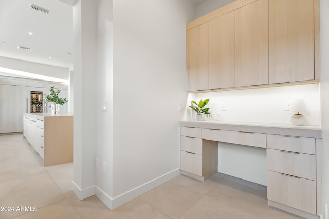 unfurnished office featuring built in desk and light tile patterned floors