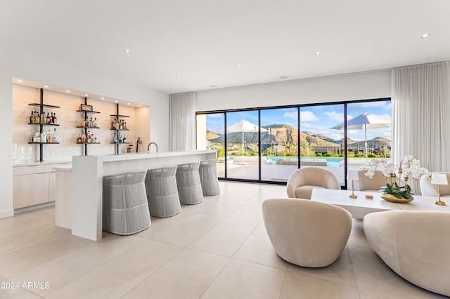 tiled living room featuring bar and a mountain view