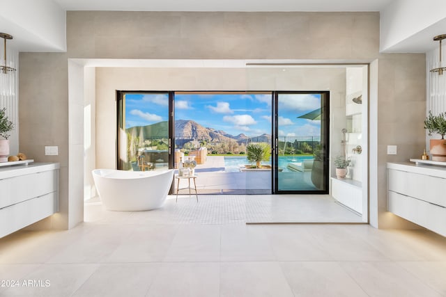 doorway to outside with light tile patterned flooring, a mountain view, and plenty of natural light