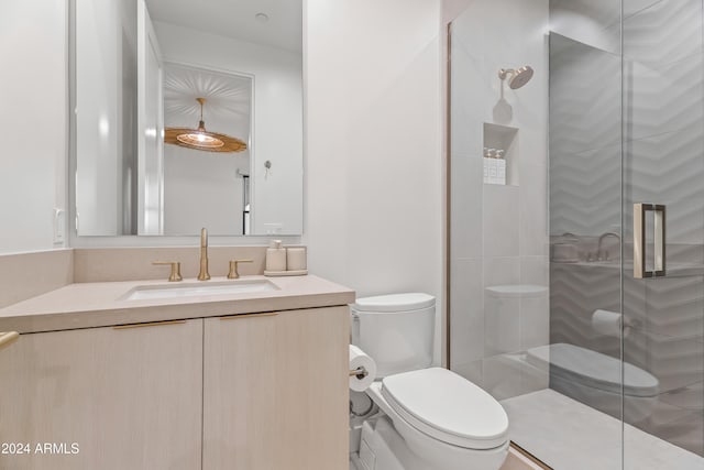 bathroom featuring a shower with door, toilet, and vanity