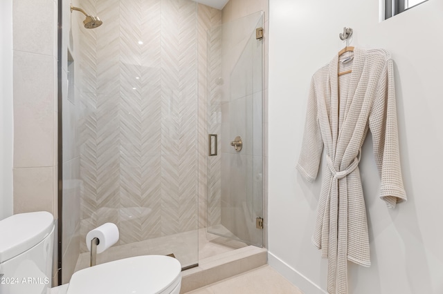 bathroom featuring toilet, a shower with shower door, and tile patterned floors