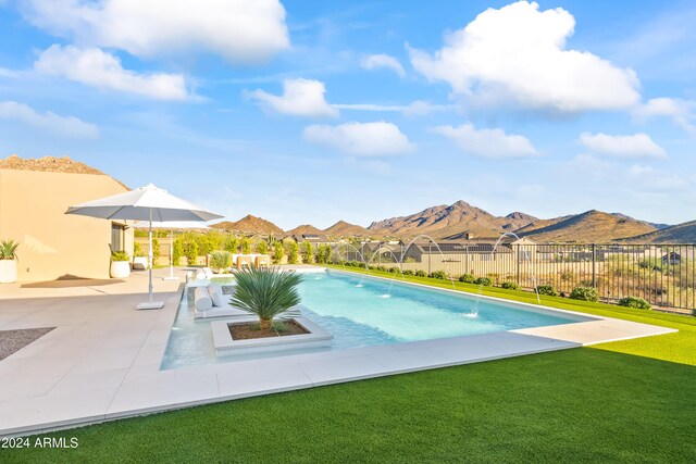 view of pool with a yard, a patio, pool water feature, and a mountain view