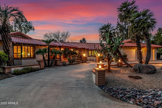 mediterranean / spanish-style home with a garage and an outdoor fire pit