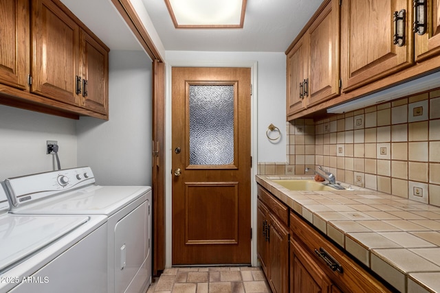 laundry area featuring cabinets, washing machine and clothes dryer, and sink