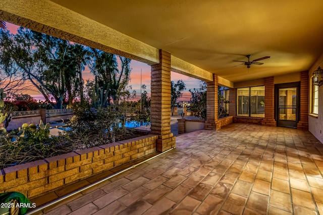 patio terrace at dusk featuring ceiling fan