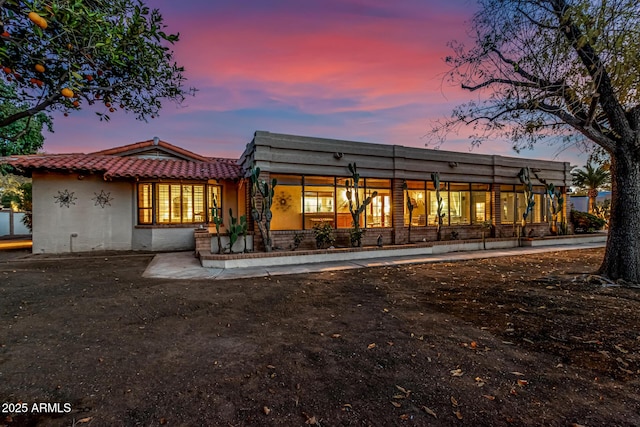 view of back house at dusk