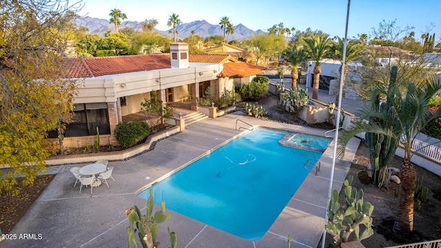 view of pool with a mountain view, a patio area, and an in ground hot tub