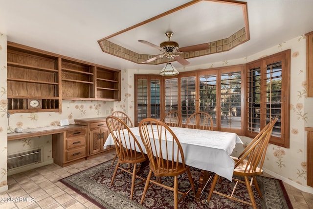 dining room featuring a raised ceiling and ceiling fan