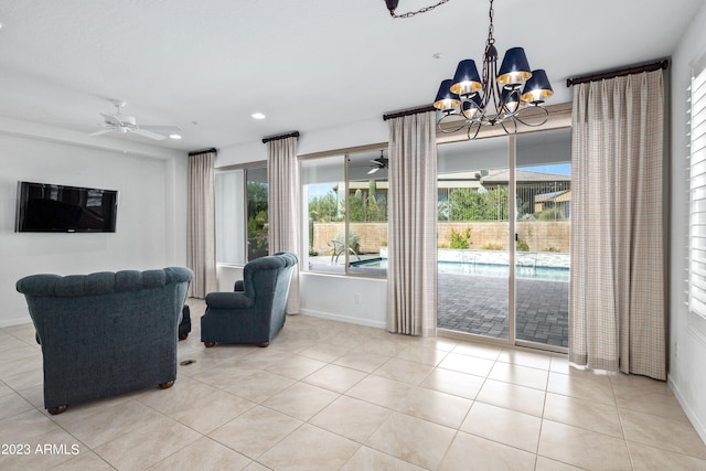 living room with ceiling fan with notable chandelier and light tile flooring