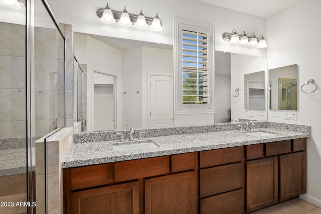 bathroom with dual sinks, tile flooring, a shower with door, and vanity with extensive cabinet space