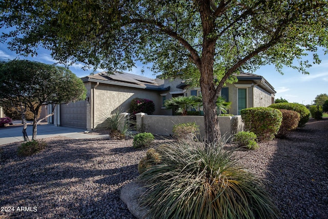 view of front of property with solar panels and a garage