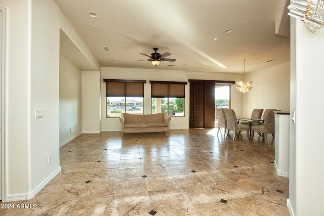 interior space with ceiling fan with notable chandelier