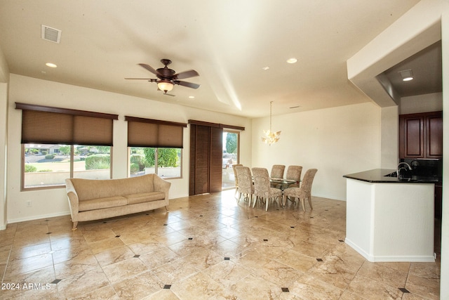 unfurnished living room featuring ceiling fan with notable chandelier