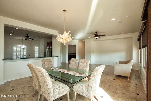 dining room featuring ceiling fan with notable chandelier