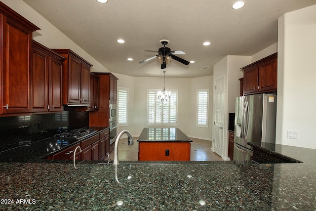 kitchen featuring stainless steel appliances, dark stone counters, a kitchen island, and tasteful backsplash