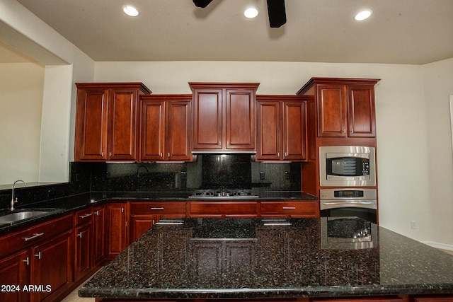 kitchen featuring dark stone counters, sink, backsplash, and appliances with stainless steel finishes