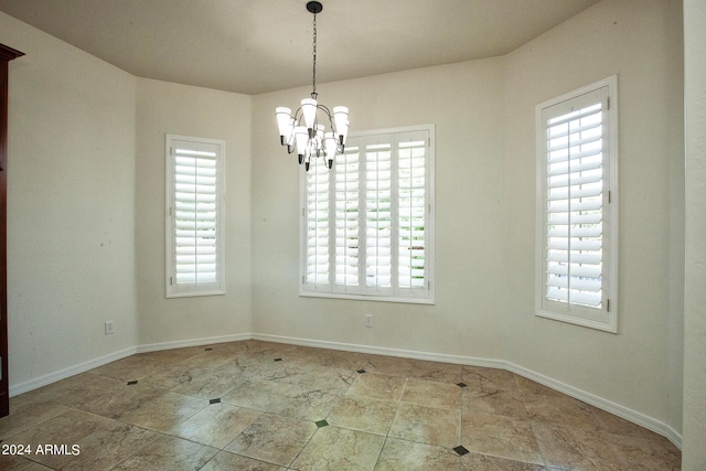 unfurnished dining area with plenty of natural light and an inviting chandelier