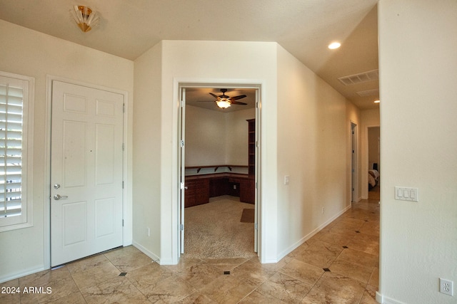 foyer entrance with light colored carpet and ceiling fan