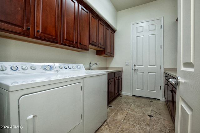 washroom featuring washing machine and dryer, cabinets, and sink