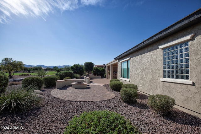 view of yard featuring a mountain view, a fire pit, and a patio