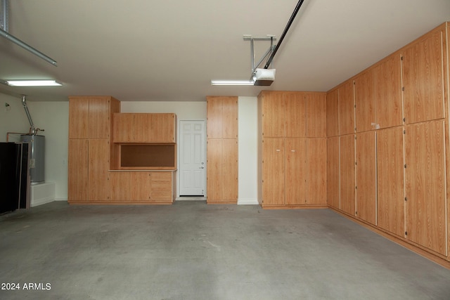 garage featuring water heater, wood walls, and a garage door opener