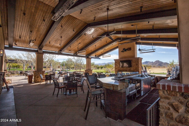 view of patio featuring a gazebo, exterior fireplace, an outdoor bar, an outdoor kitchen, and a mountain view