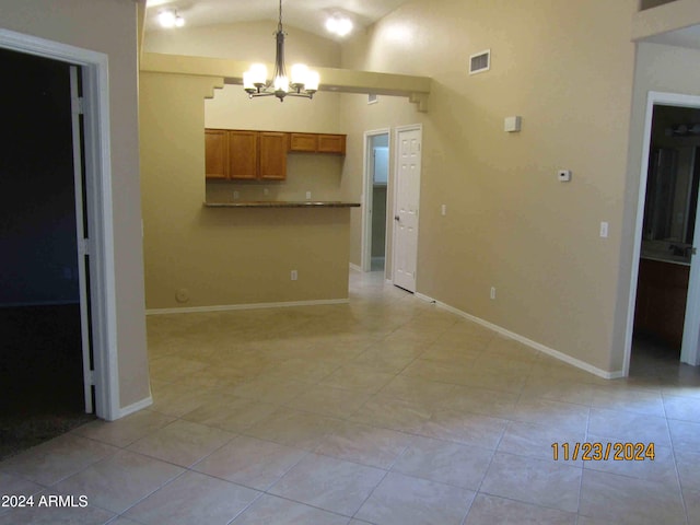 unfurnished living room featuring light tile patterned floors, an inviting chandelier, and lofted ceiling