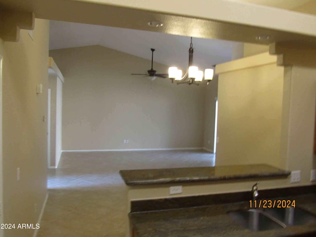 kitchen featuring pendant lighting, ceiling fan with notable chandelier, sink, vaulted ceiling, and light tile patterned flooring