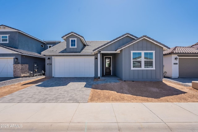 11857 N Luckenbach St, Surprise, AZ 85388 - ranch-style home with driveway, board and batten siding, an attached garage, and a tiled roof