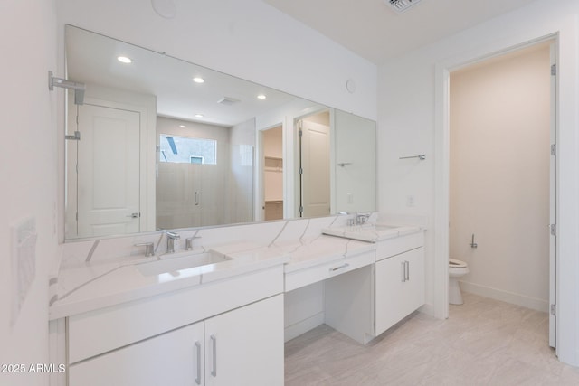 11857 N Luckenbach St, Surprise, AZ 85388 - full bathroom featuring a stall shower, double vanity, toilet, a walk in closet, and recessed lighting