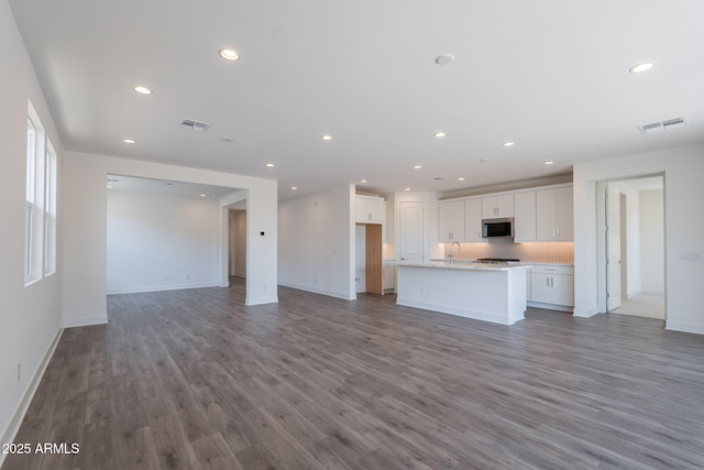 11857 N Luckenbach St, Surprise, AZ 85388 - unfurnished living room featuring a sink, wood finished floors, recessed lighting, and baseboards