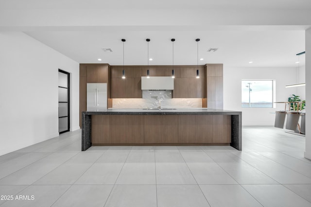 kitchen with high end fridge, sink, light tile patterned floors, pendant lighting, and backsplash