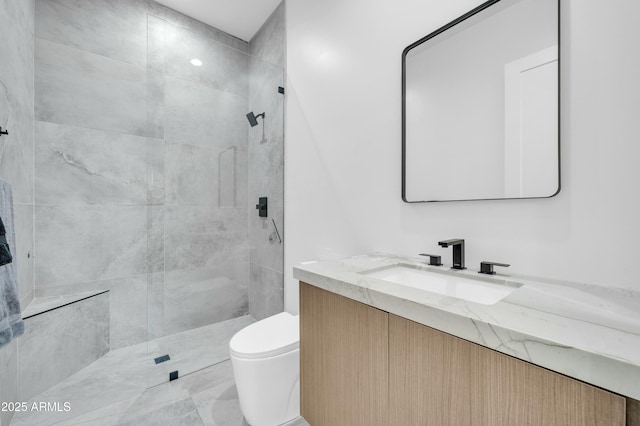 bathroom with vanity, toilet, and a tile shower