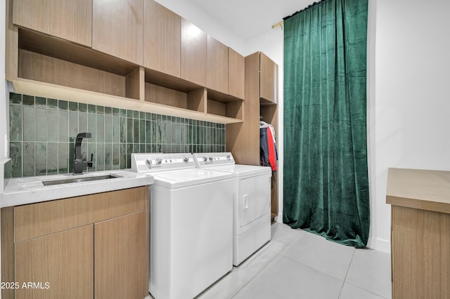 washroom with cabinets, separate washer and dryer, sink, and light tile patterned floors