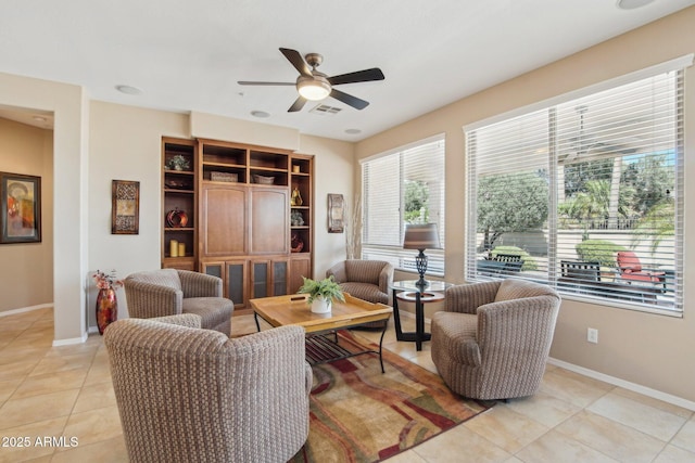 living area with light tile patterned floors, visible vents, baseboards, and ceiling fan