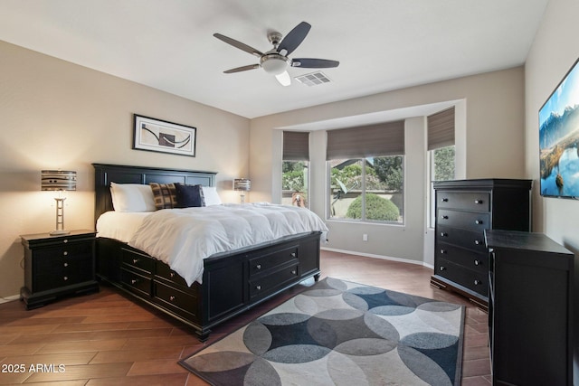 bedroom featuring baseboards, ceiling fan, visible vents, and wood finished floors