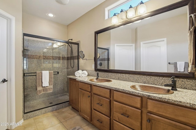 bathroom with tile patterned floors, a stall shower, and a sink