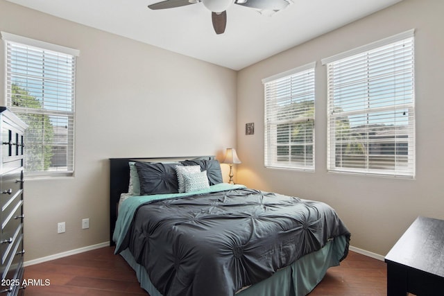 bedroom with baseboards, multiple windows, and dark wood-style flooring