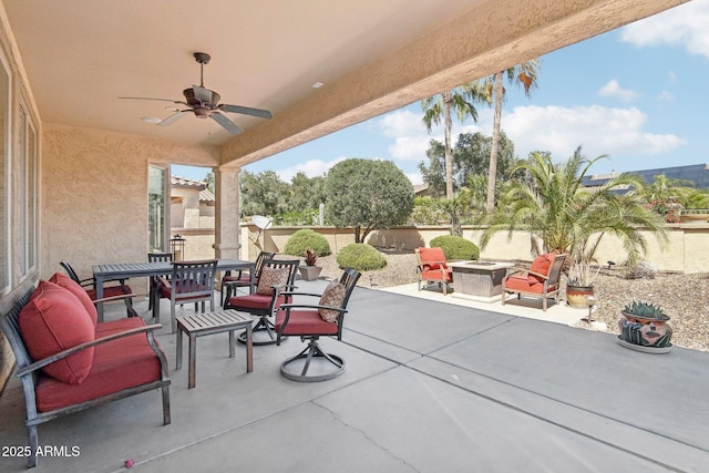 view of patio with an outdoor fire pit, outdoor dining area, a ceiling fan, and a fenced backyard