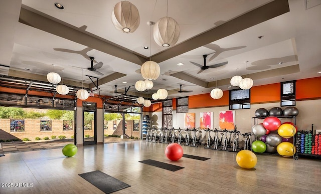 workout area featuring plenty of natural light, wood finished floors, and a ceiling fan