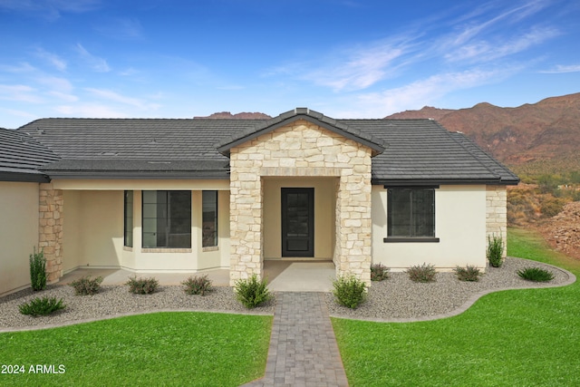 view of front facade featuring a mountain view and a front yard