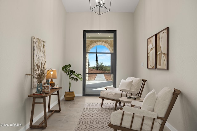 living area featuring an inviting chandelier and light hardwood / wood-style flooring