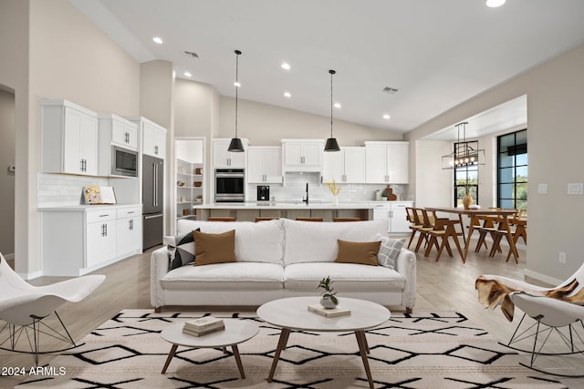 living room with high vaulted ceiling and light hardwood / wood-style floors