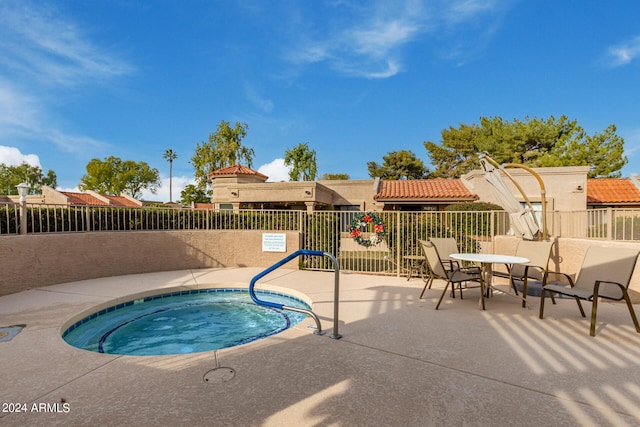 view of pool with a hot tub and a patio area